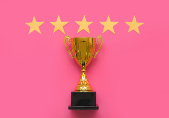 Gold cup with stars on pink background