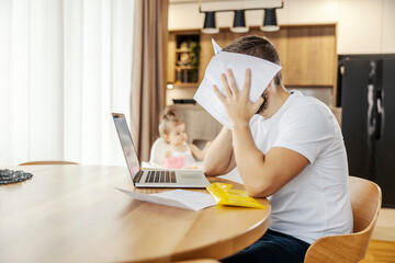 A nervous man is having troubles with home finances while babysitting his daughter.