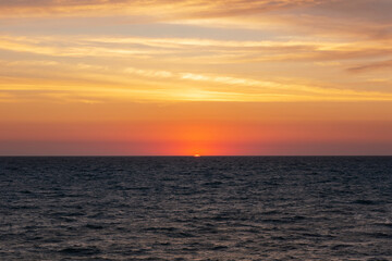 Sunset on the sea in the clouds with sun rays