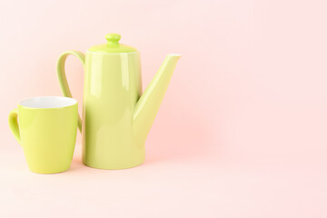 Teapot and mug on pink background
