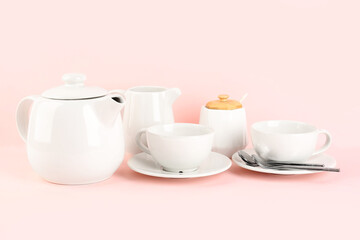 Stylish tea set on pink background