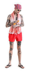 Tattooed man applying sunscreen cream on white background