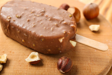 Wooden board with tasty chocolate covered ice cream on table, closeup