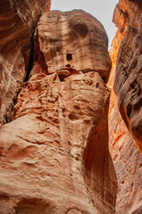 Canyon Siq or El Siq in Petra Jordan. Only road to rock city of Nabatean kingdom, to ancient city of Petra. Huge rocks hang over a narrow path, 92 to 182 meters high