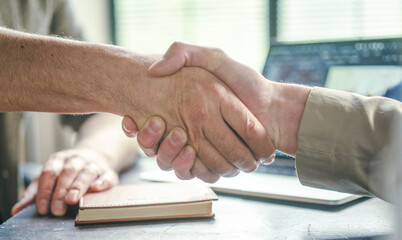 Fototapeta na wymiar Handshake exemplifies values of trust, collaboration, and teamwork within corporate environment, emphasizing importance of establishing strong connections in business world. Close-up, hands of two men