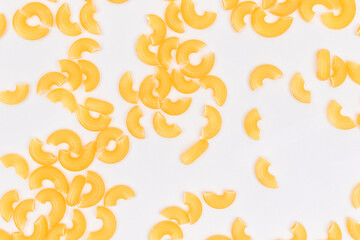 Scattered Uncooked Chifferi Rigati Pasta on White Background. Fat and Unhealthy Food. Classic Dry Macaroni Texture. Italian Culture and Cuisine. Raw Pasta