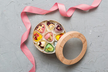 Holiday composition: sweet candy, with gift boxes with bow and chocolate hearts, photo template, background. Top View with copy space on colored background