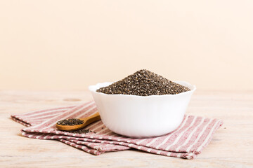 Chia seeds in bowl and spoon on colored background. Healthy Salvia hispanica in small bowl. Healthy superfood