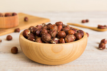 Wooden bowl full of hazelnuts on table background. Healthy eating concept. Super foods