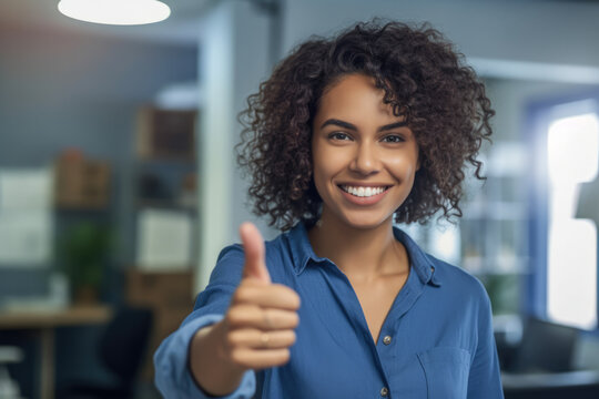 Close up of a woman at work smiling with a thumb up. 