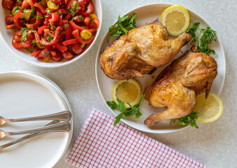 Roast half chicken  with salad on white table. Top view