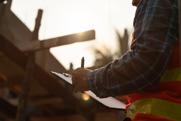 inspector or engineer is inspecting construction and quality assurance new house using a checklist. Engineers or architects or contactor work to build the house before handing it over to the homeowner