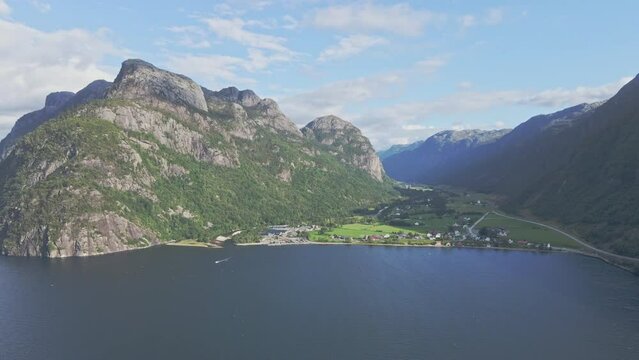 Village nestled between mountains along the blue waters of a fjord in Norway