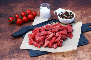 Rindergeschnetzeltes: In Streifen geschnittenes rohes Rindfleisch mit Tomaten und Gewürzen.	