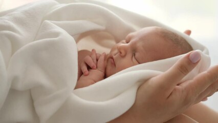Adorable newborn baby sleeping on his mother hands. Closeup view of infant child swaddled in blanket napping and his mom cares about him - Powered by Adobe