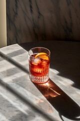 A beautiful high end whiskey cocktail sitting on a marble table