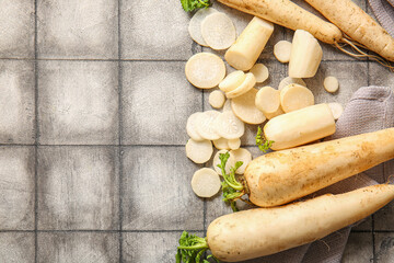 Fresh daikon radishes on grey tile background