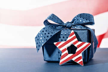 Blue Gift box with stripy star against US American flag. Happy Independence Day. Stars and stripes. Copy space. memorial day