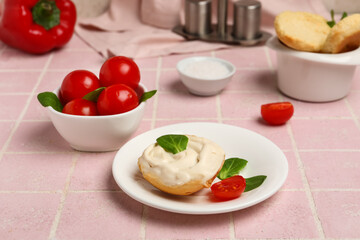 Plate of tasty crouton with cream cheese on pink tile background