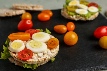 Rice cracker with quail eggs, tomatoes and lettuce on table, closeup