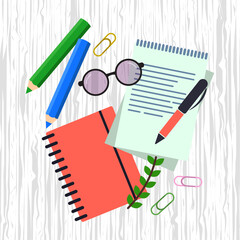 Notepad for writing or drawing, planner, workplace organization with stationery items on wood surface.