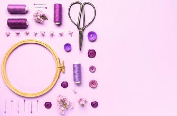 Wooden embroidery hoop with sewing supplies on lilac background