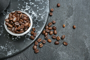 Bowl with coffee beans on black background