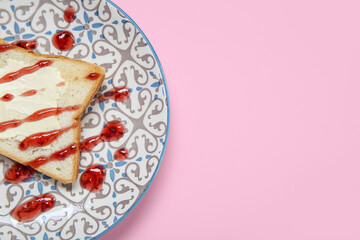 Plate of toast with butter and jam on pink background, closeup