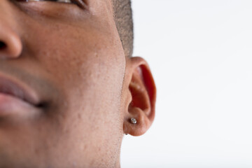 Earring detail on black man's blurred smile
