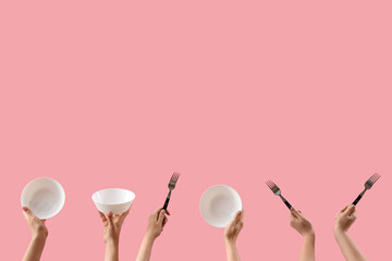 Female hands holding bowls and forks on pink background