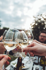 Freunde stoßen an einem lauen Sommerabend mit Weißwein an