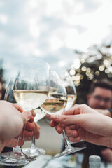 Freunde stoßen an einem lauen Sommerabend mit Weißwein an