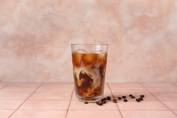 Glass of tasty ice coffee with milk on table