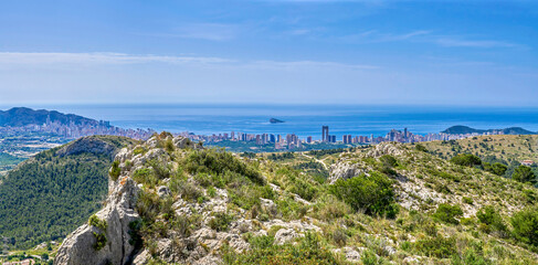 A man contemplates the city of Benidorm from the mountains and the sea in the background. Landscape of the Mediterranean coast. Located in the Valencian community, Alicante, Spain