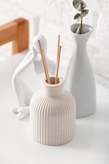 Bottle of reed diffuser and decor on table, closeup