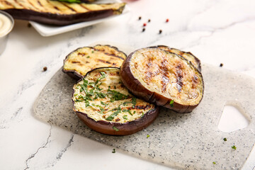 Delicious grilled eggplants on light background