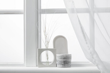 Holder with candle and decor on windowsill in room