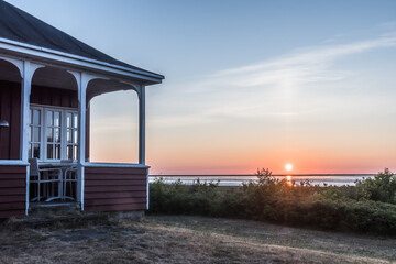 Fototapeta na wymiar Sunrise over the sea, view to the woden corner of a veranda