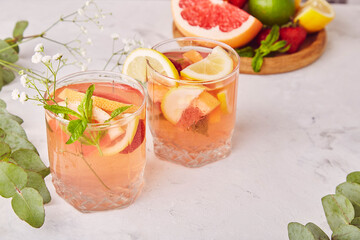 Non alcoholic refreshing tonic with citrus fruits. Two drinking glasess. Summer detox cold cocktails