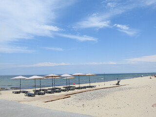 beach  of the baltic sea with umbrellas and chairs