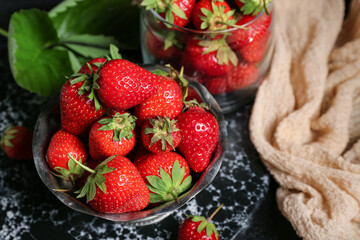 Bowl and glass with fresh strawberries, closeup