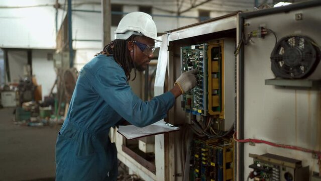 Professional electric engineer or repairman inspecting a broken electrical circuit board or fuse board in the factory.