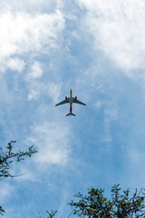 Avión en el cielo azul con nubes desde abajo, avión de pasajeros de alto vuelo. 