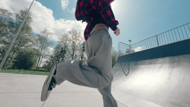 teenage girl running and climbing up on a ramp in a skate park