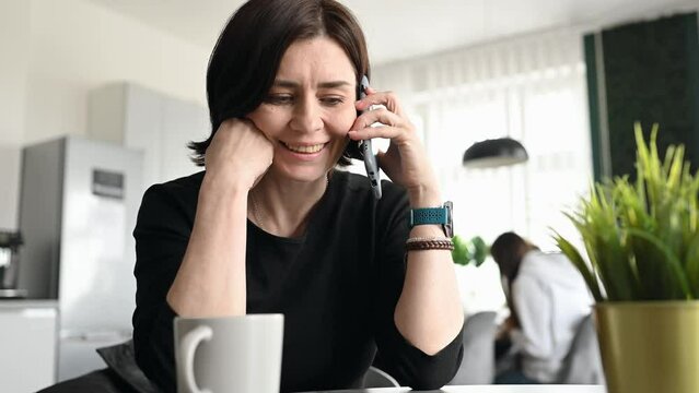 girl talking by the smartphone in the kitchen of of coworking space