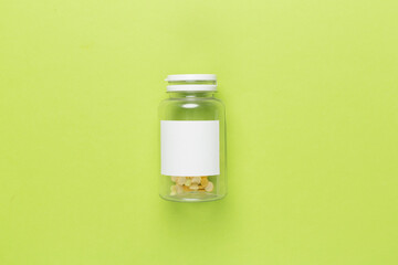 Plastic bottle with vitamins on color background, top view