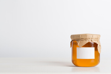 Jar with honey on wooden table. Mock up design