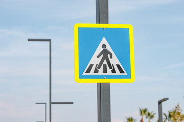 Pedestrian crossing sign at busy city street