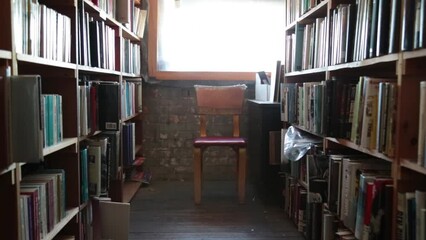 old bookstore with an empty chair in front of a window showing isolation