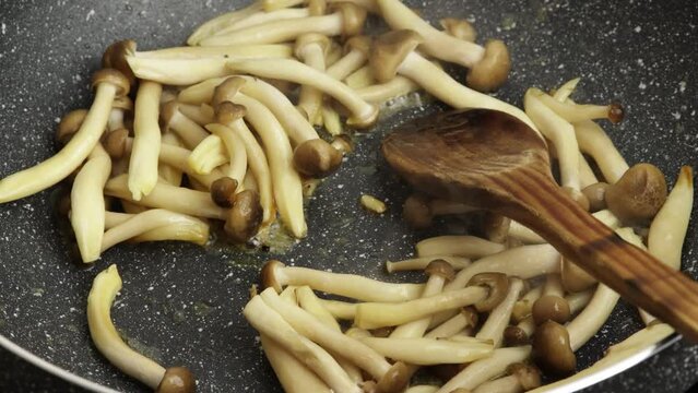 groupe de champignons bruns bunas Himeji cuisant dans une po&ecirc;le